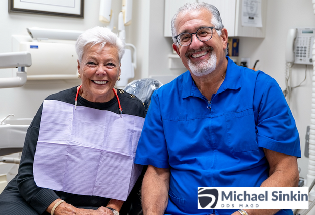 A happy patient sitting with Dr. Michael Sinkin, both smiling after an anxiety-free smile makeover.