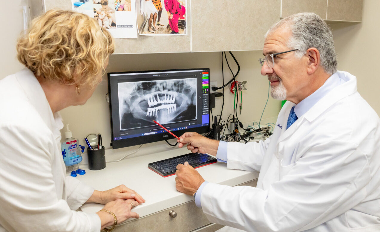 Dr. Michael Sinkin discussing dental implant treatment with a patient