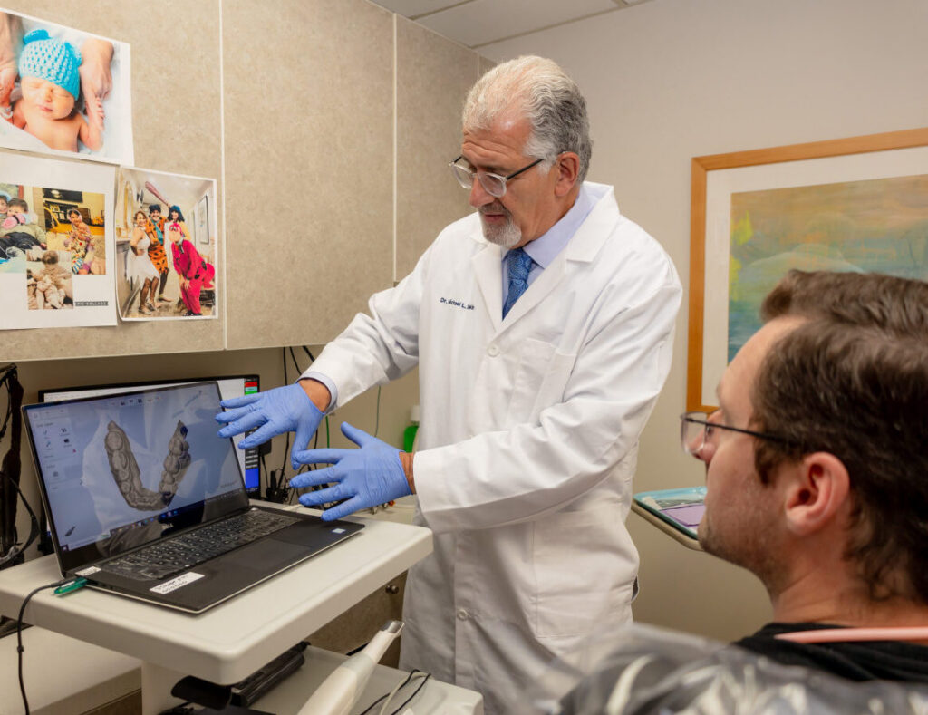 Dr. Michael Sinkin reviewing 3D dental imaging with a patient in his Midtown Manhattan office
