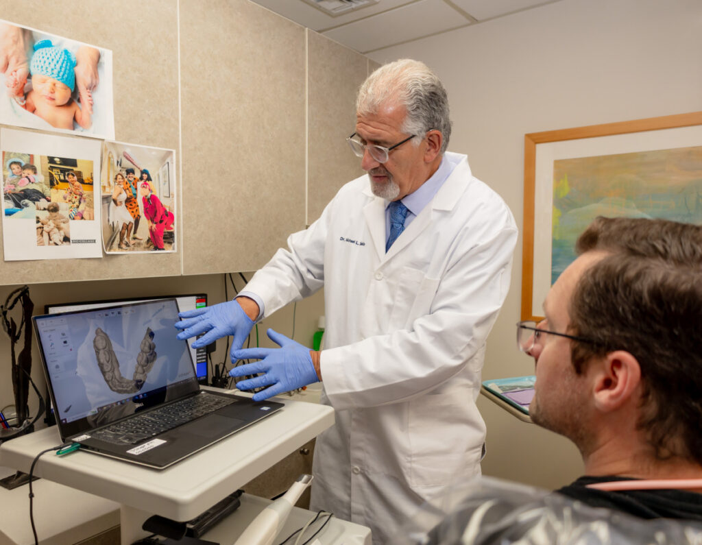 "Dr. Michael Sinkin reviewing a full mouth reconstruction treatment plan with a patient in his Midtown Manhattan dental office