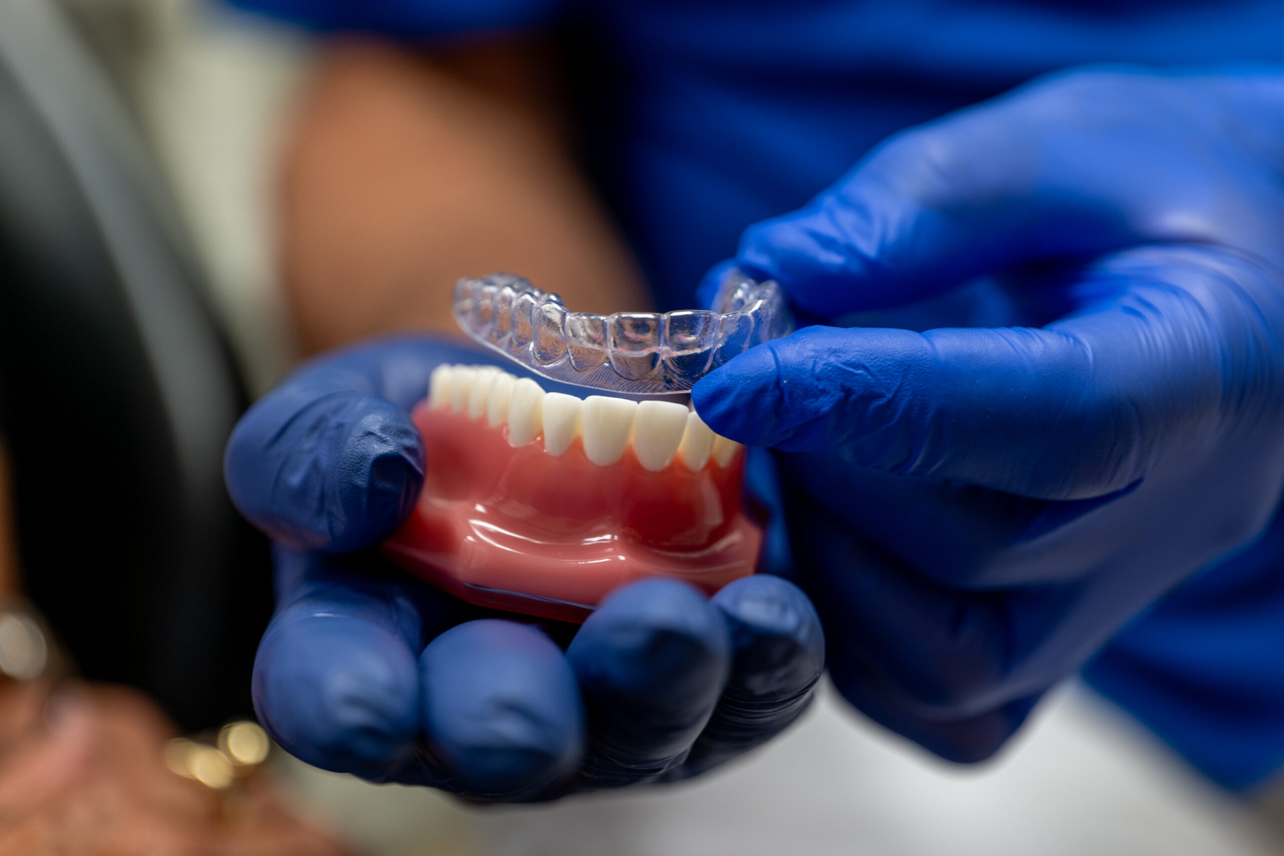 Dr Sinkin showing a patient a clear Invisalign aligner in a Midtown Manhattan dental office